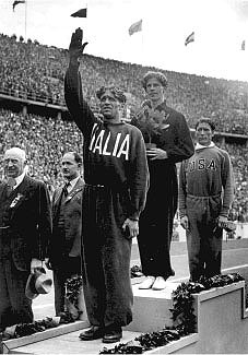 The medal ceremony for the 1500 metres at the 1936 Olympics, Berlin. Left to right: Luigi Beccali (bronze), Jack Lovelock (gold), Glenn Cunningham (silver). Arthur Porritt, manager of the New Zealand team stands in the background, second from left. Photographer: unknown, chromogenic (colour) photograph, 2004, Jack Lovelock Papers , Manuscripts & Archives Collection, Refs: MSX-2261-066, C-024465-1/2 and MS-Group-0012, Alexander Turnbull Library