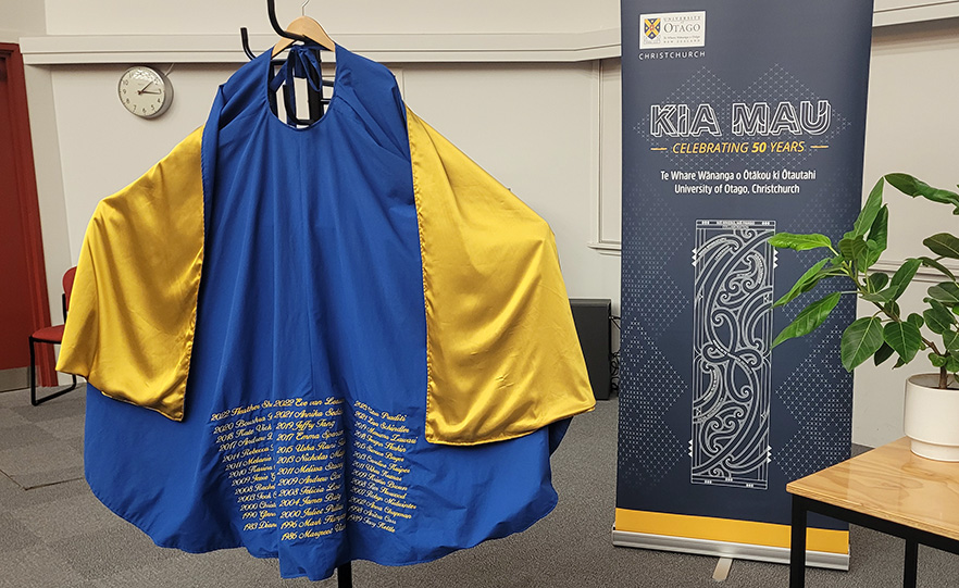 Blue and gold cloak embroidered with the names of Centre for Free Radical Research PhD graduates image