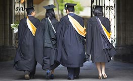 Students walking wearing graduation gowns