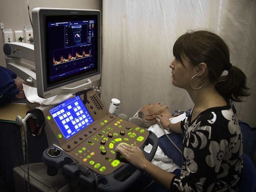 Female sonographer performing an ultrasound carotid scan