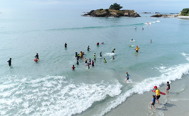 Drone image of kids playing in surf 