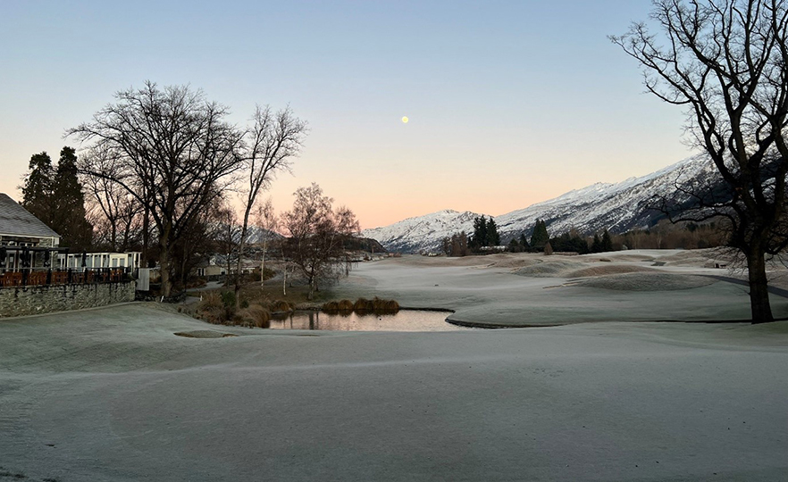 Resort with golf green and snowy mountain image
