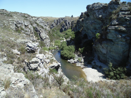 Manuherikia River gorge downstream of the historic Daniel O'Connell Bridge, Ophir. The river is cutting down into schist bedrock, as the gentle northwestern slopes of the Raggedy Range are being slowly uplifted. The rail trail climbs along the edge of the schist bedrock over Tiger Hill, to the west (right) of this gorge.