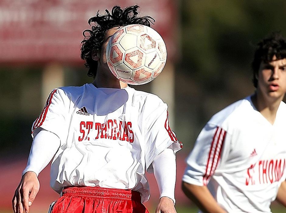 Footballer being hit in the face by football