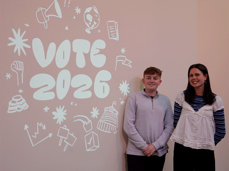 students standing in front of Vote 2026 sign