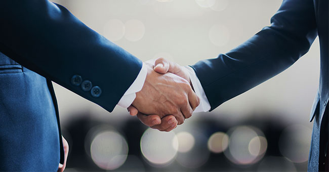 Two men in suits shake hands image