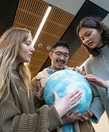 Students holding a globe
