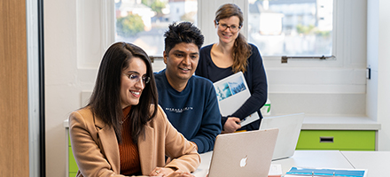 Three pharmacy students viewing a laptop