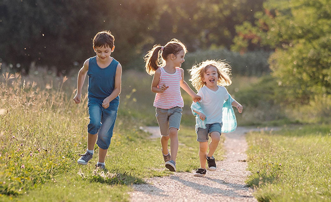 Children running in a meadow full image