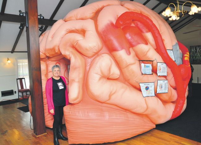 A woman standing in front of a large inflatable brain