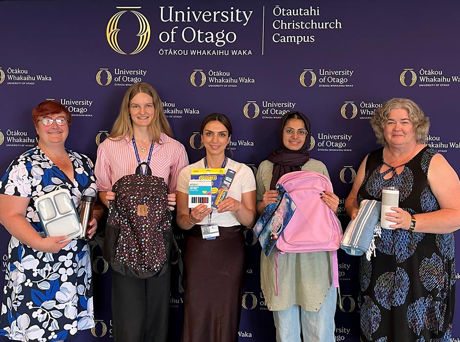 UOC-holiday collection team in from of Otago backdrop