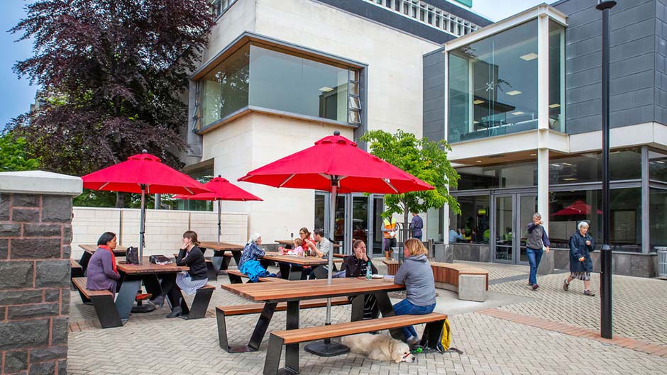Customers sitting under sun umbrellas at a few tables outside the St David Café