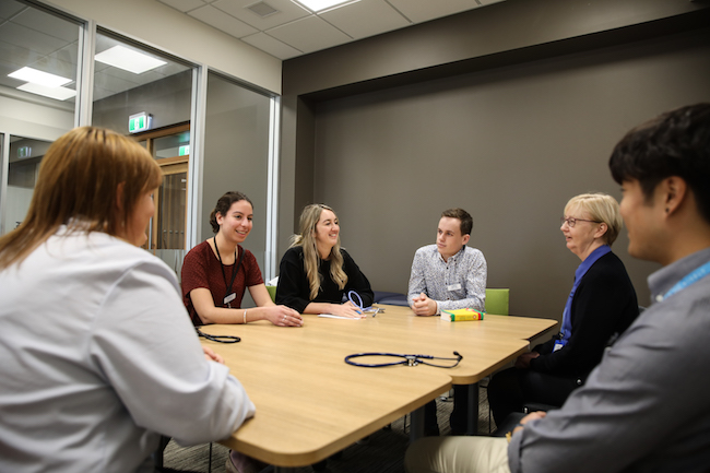 Staff and students in disussion in one of the meeting rooms at the Health Sciences Southland Study Hub