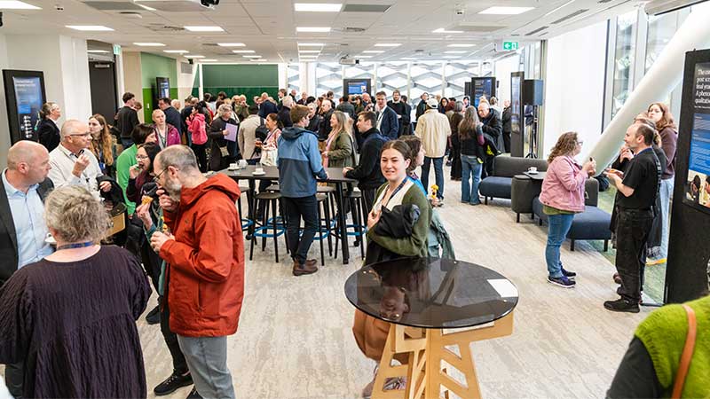 People standing in a room chatting and looking around