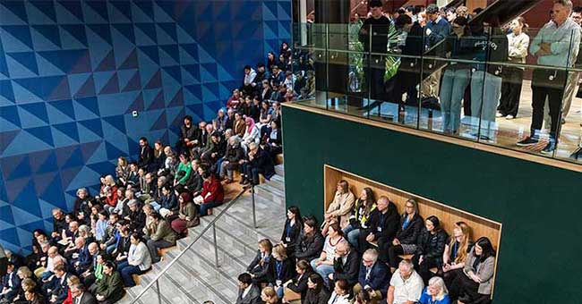 Looking from above at a large group of people seated in an auditorium