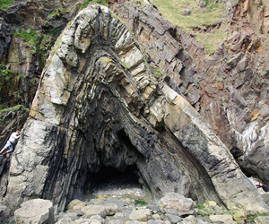 An imposing anticline on the coast of Pembrokeshire, south Wales. People show both scale and inferred direction of compression.