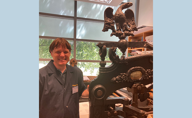 Student Derek Whaley, a Senior Research Librarian at Auckland Library, beside one of the presses image