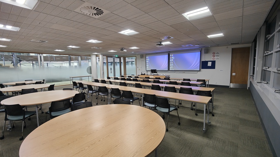 View of Otago Business School room G19, showing tables and chairs in rows and groups