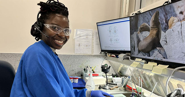 A woman wearing scrubs working in a lab