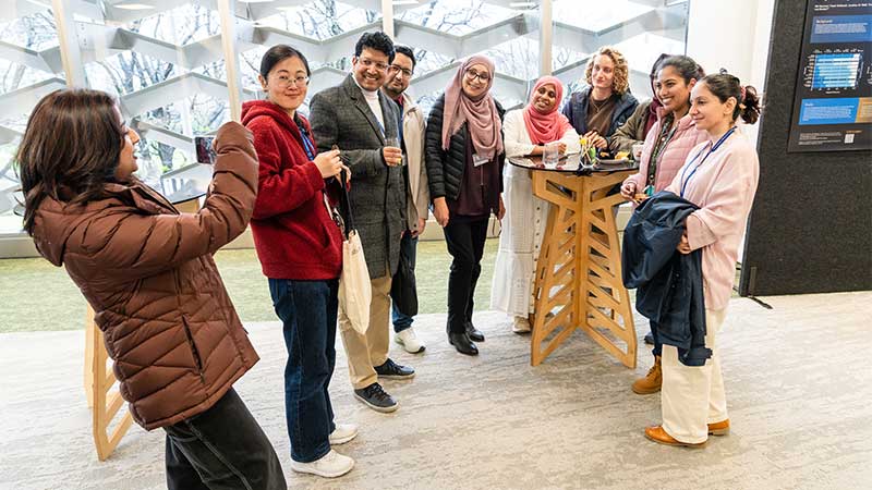 A handful of people standing smiling while someone takes their photo