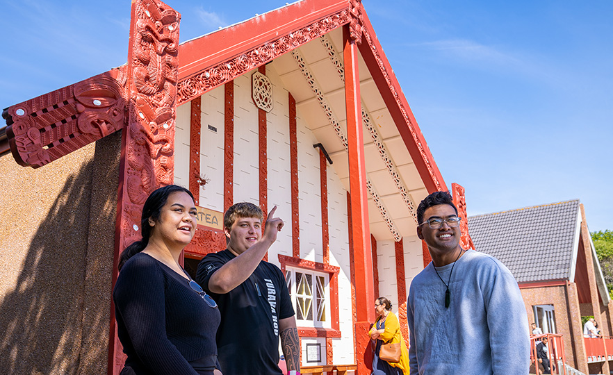 Three Maori Students standing in front of Otakou Marae Image Feb 2021