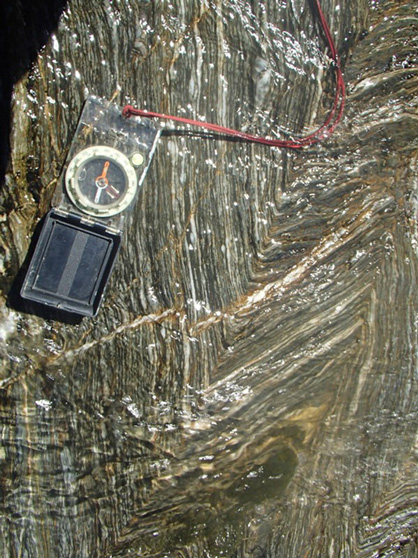 Chevron folds with ankerite mineralisation parallel to the foliation and quartz and ankerite veins crosscutting the foliation. The folds are related to the thrusting activity along the moonlight fault (Craw et al., 2006).