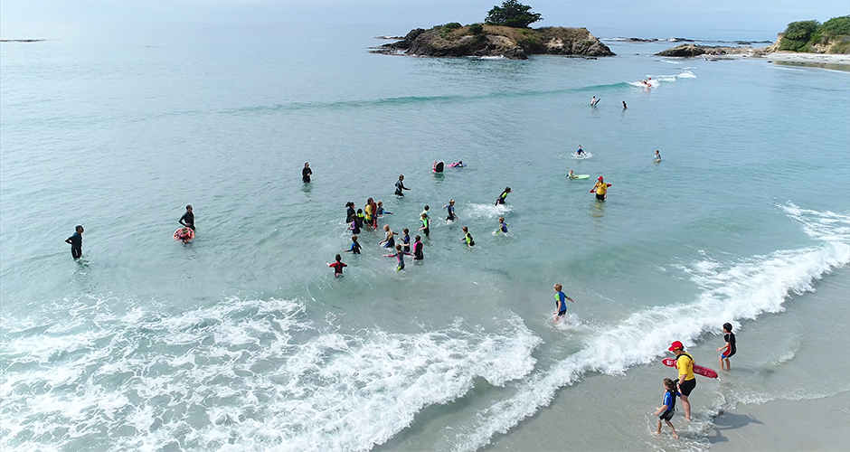 Drone image of kids playing in surf 