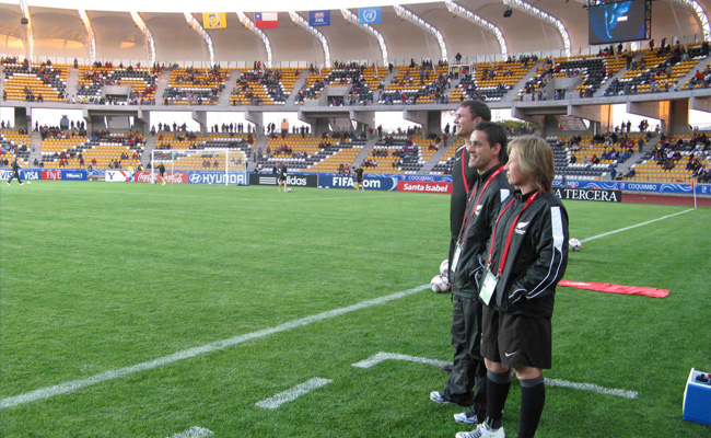 football stadium with coaches standing on the sideline 