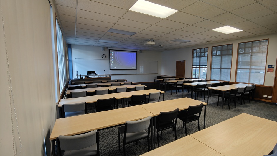 A view of Ōwheo building seminar room G34, showing rows of tables and chairs