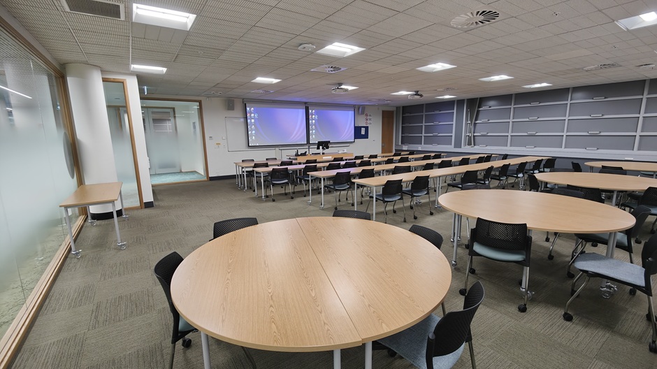 View of Otago Business School room G19, showing tables and chairs in rows and groups