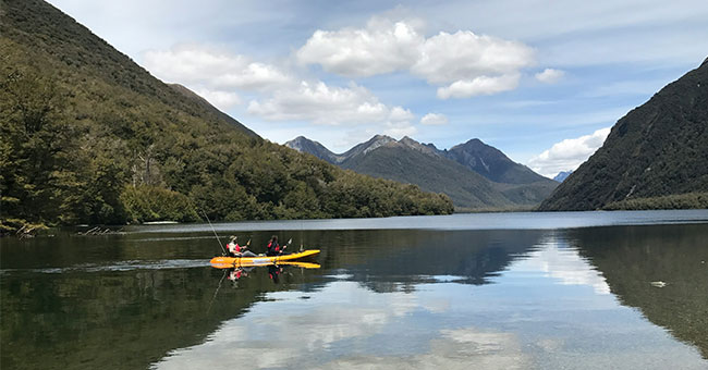 An image of two people on a boat in Te Anau enjoying leisure time.