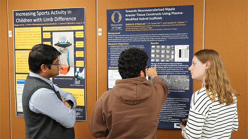 three people looking at a poster 
