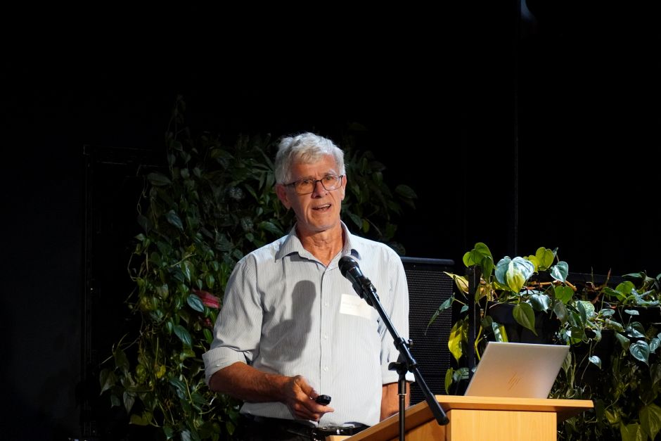 A man addresses an audience from a podium
