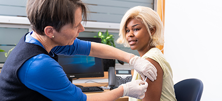 Pharmacist giving a flu jab in clinic