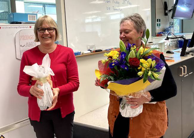 Liz gives Kaye wine and flowers