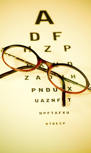A pair of glasses resting on an eye chart