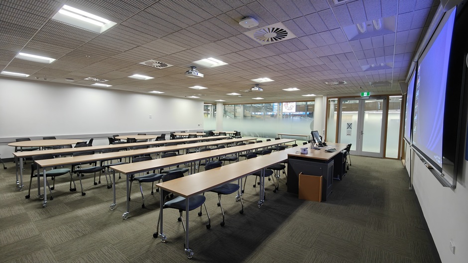 View of Otago Business School room G19, showing tables and chairs in rows and groups