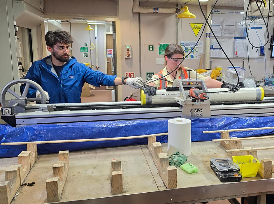 Geology PhD student Rachael Baxter steadies a tube of core, extracted using a multi corer.
