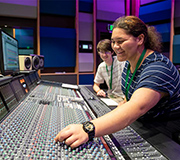 Two students mixing music in a music studio.