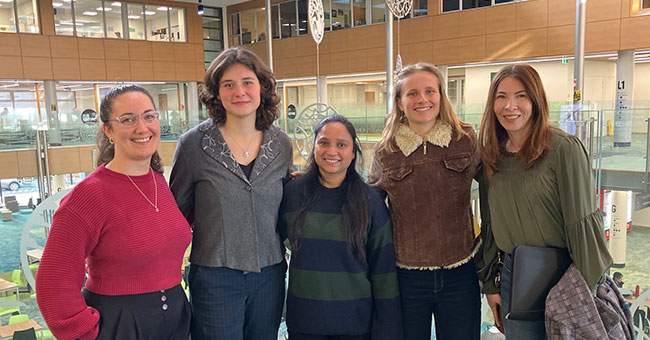 A group of women pose for a photo in the Business School.