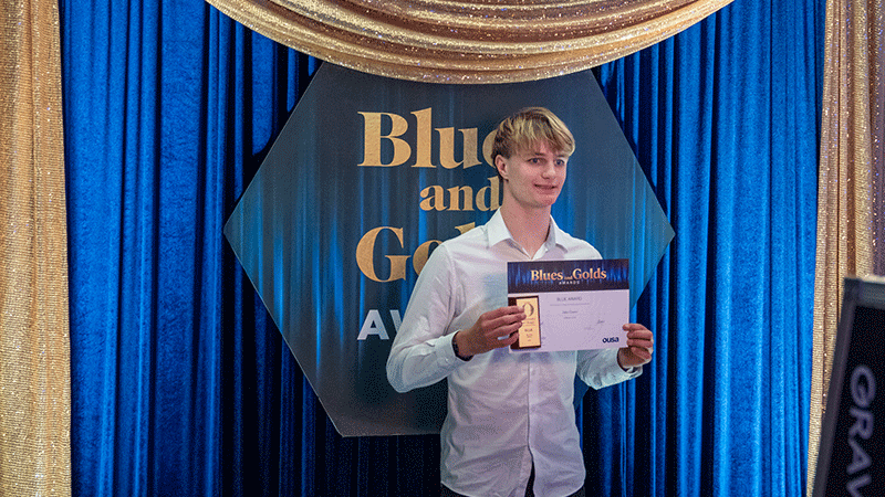 man holding certificate in front of display wall