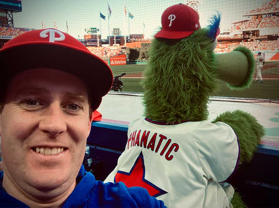 A man standing next to a mascot at a sports stadium