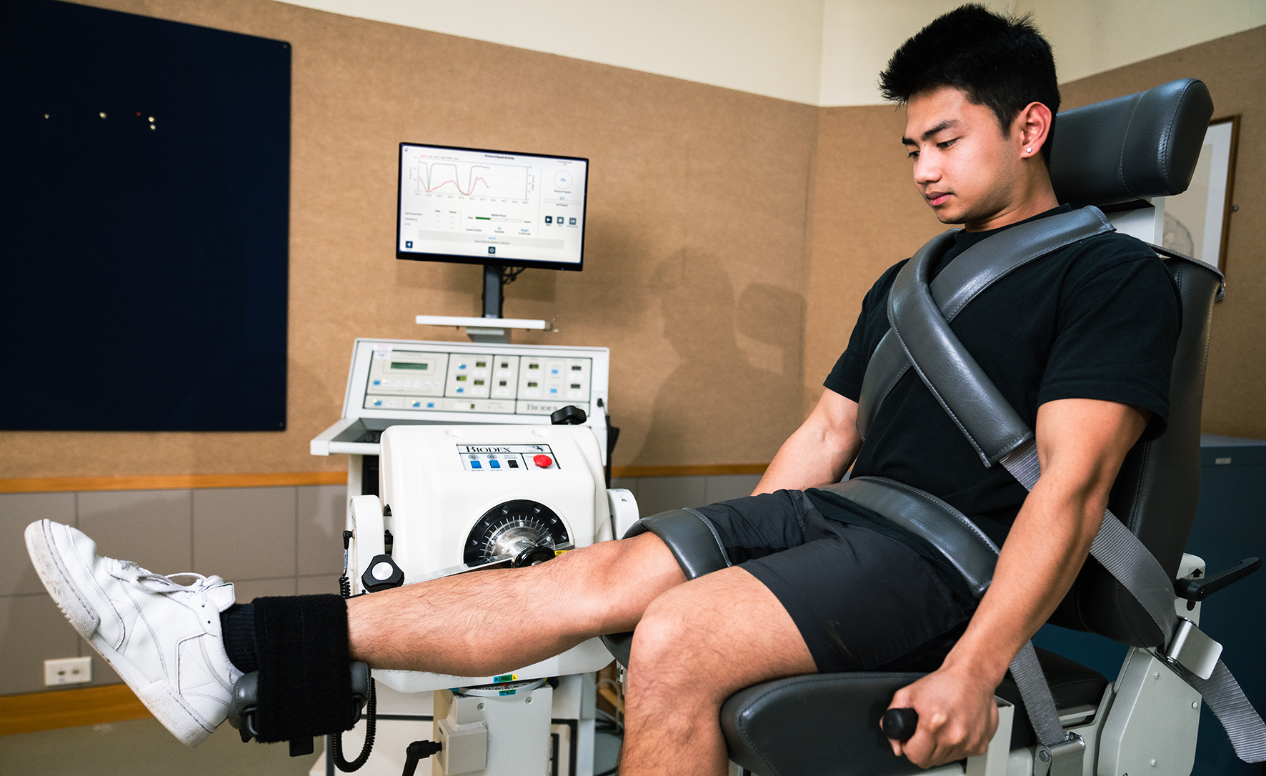 Man stapped to a chair exercising his leg image