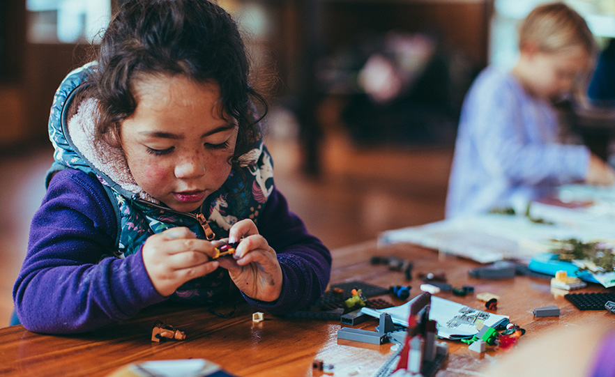 A small child playing with Lego bricks stock image