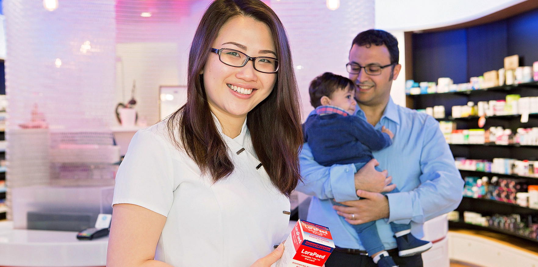 Pharmacist oh the shop floor with a patient and his young son