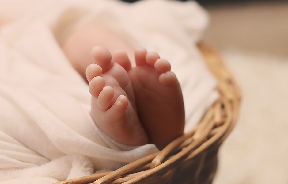 A close-up image of a newborns feet as they sleep.