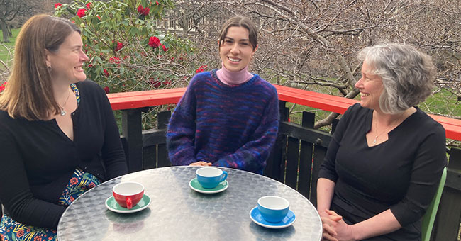 Three woman sitting at a table at a cafe 