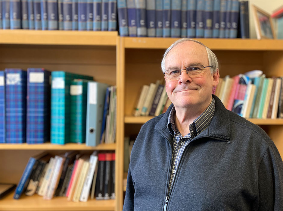 A man standing in front of a book case