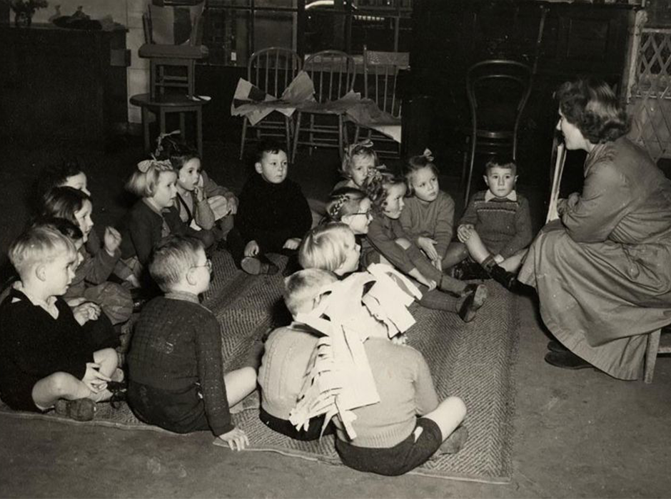 Female teacher reading story to children