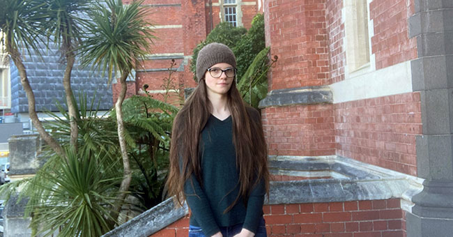 A girl in a beanie standing in front of Victoria University's Hunter building